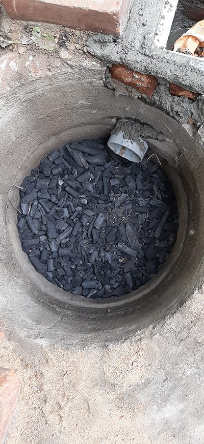 Charcoal filter layer inside a recharge well
