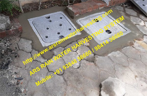 Two finished recharge chambers with perforated covers set into paving